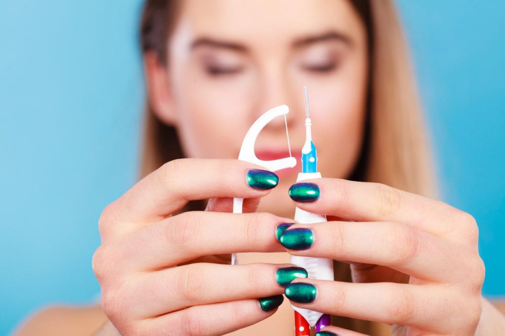 Woman flossing with braces